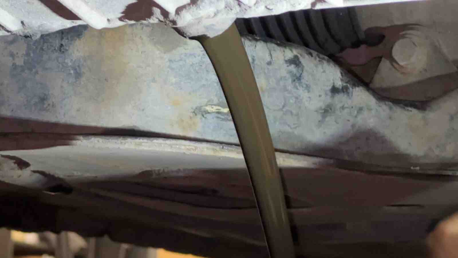 Draining old oil from under a car