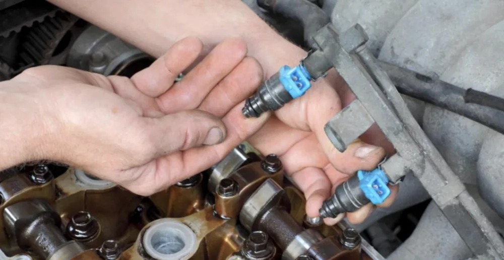 Petrol injectors with blue connectors on the fuel rail with the valve cover removed