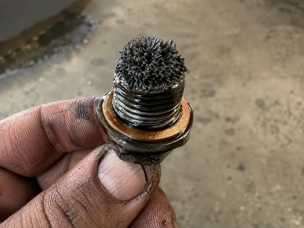 Magnetic drain plug covered in metallic sludge