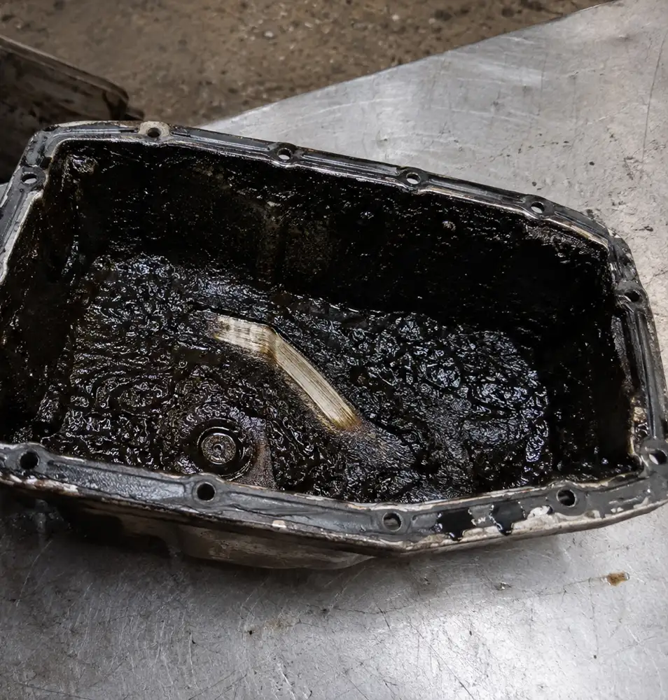 Removed diesel oil sump with a thick layer of sludge on the bottom
