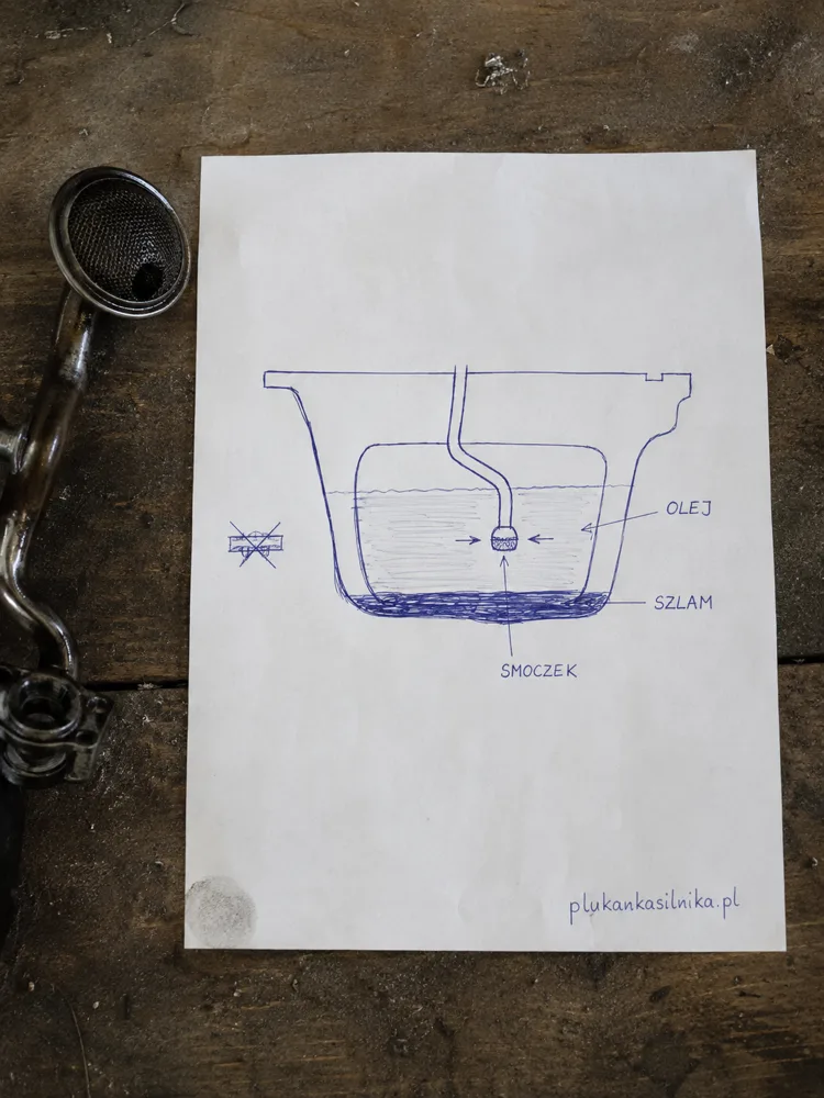 Hand drawn ballpoint sketch on paper: a cross section of an oil sump with a layer of sludge at the bottom and the oil pump pickup strainer sitting in the oil