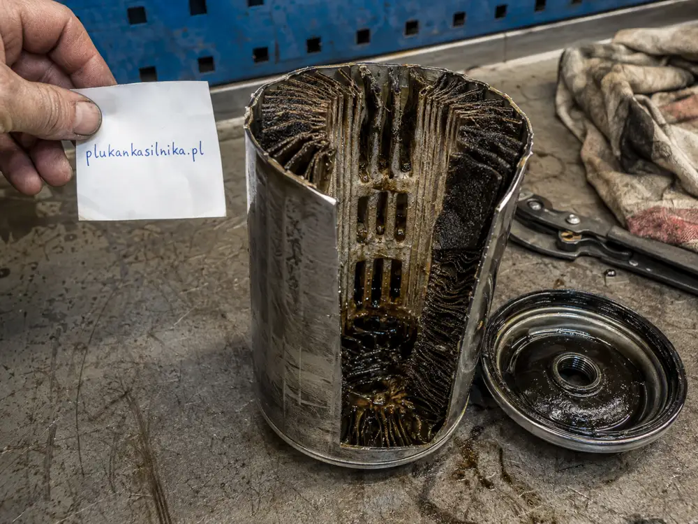 Oil filter cut open, pleats loaded with dark sludge