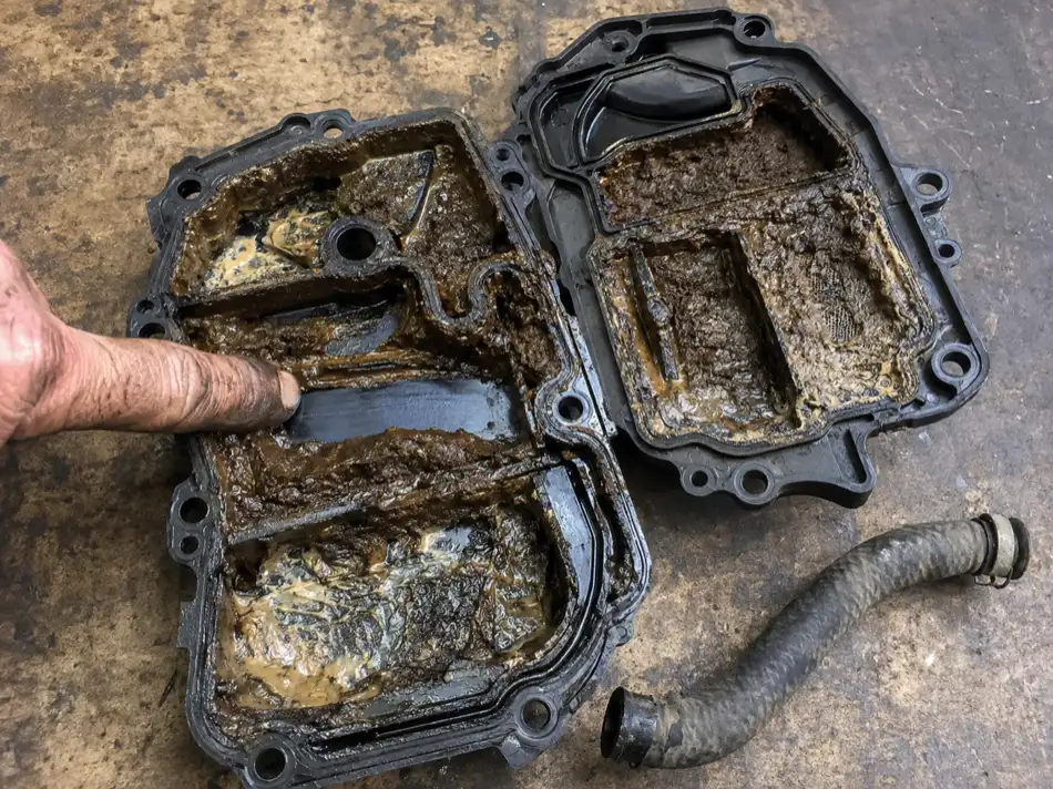 Opened oil separator with its chambers clogged by brown deposit